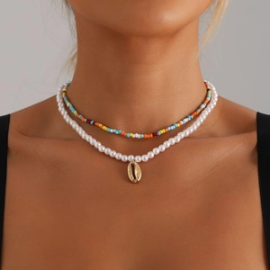 Bohemian layered choker featuring colorful seed beads, faux pearls, and a gold shell pendant
