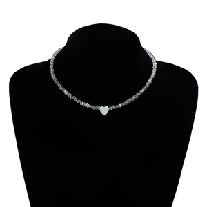 Detail of silver beaded necklace with heart pendant on a black mannequin neck display