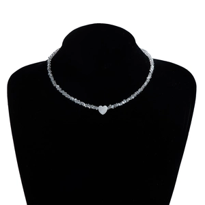 Macro view of handmade glass crystal beaded necklace with white heart pendant on neck model