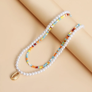 Detail of bohemian layered necklace with colorful beads, imitation pearls and shell pendant