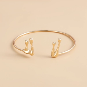 Dettaglio del bracciale aperto stile lava liquida con trama dorata e finitura a specchio