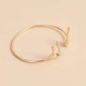 Bracciale rigido aperto oro chiaro design lava liquida con goccia d'acqua minimalista