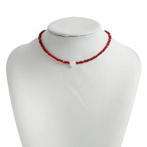 Detail of red crystal beaded choker necklace with a central white heart pendant