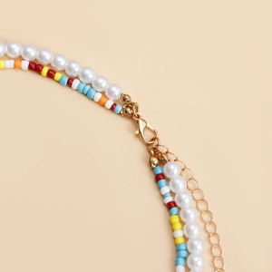 Close-up of golden lobster clasp and adjustable chain on double-layer beaded necklace