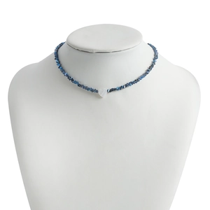 Detailed macro view of handmade blue crystal beaded necklace with a white heart shell pendant