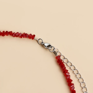 Close-up of red faceted crystal glass beaded necklace with silver lobster clasp and chain