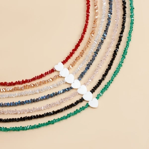 Detailed view of six colorful faceted glass beaded necklaces with heart-shaped charms