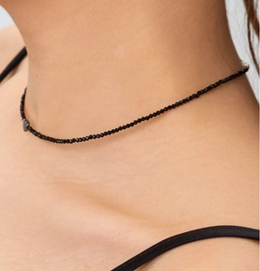 Close-up van minimalistische zwarte kralen choker ketting met kleine facetgeslepen steentjes