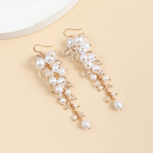 Detailed close-up of Baroque vintage drop earrings with white pearls and gold fringe tassels