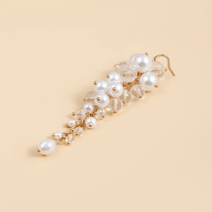 Detailed macro view of baroque style gold earrings with white pearls and crystals