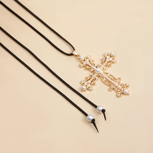 Detalle de colgante de cruz barroca con perlas y cordón de terciopelo ajustable