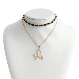 Detail van de gelaagde ketting met vlinderhanger en zwart gevlochten leren choker