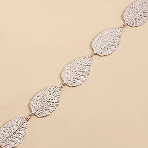 Detailed close-up of hollow rose gold leaf links on a metallic fashion waist chain belt
