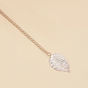 Detailed macro view of a rose gold leaf pendant with intricate镂空 mesh design and chain