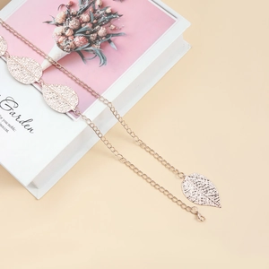 Detail of rose gold metal waist chain with hollow leaf charms and adjustable lobster clasp