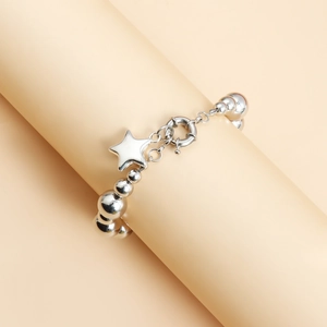 Detailed macro view of silver beaded bracelet featuring star pendant and spring clasp