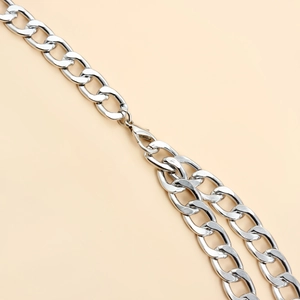 Detail of silver oval link chain with a standard lobster clasp closure in macro view