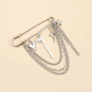 Broche de cadena plateada multicapa con corazón, estrella y perla en un imperdible