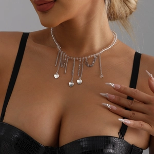 Choker necklace featuring transparent beads, silver heart pendants and long metal tassels