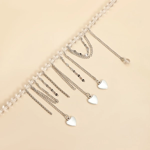 Close-up of heart tassel chain with clear beads and silver-tone metal pendants
