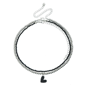 Double-layered necklace with black heart pendant and silver metal beads on white background