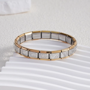 Detail of Italian charm bracelet links featuring gold and silver dual-tone heart patterns