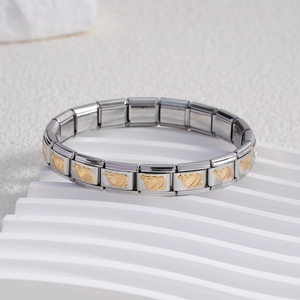 Detailed close-up of stainless steel Italian charm bracelet links with gold heart motifs