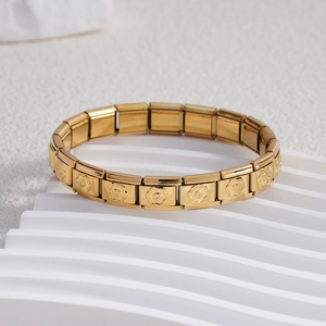 Détail du bracelet à breloques italien en or avec fleurs en relief sur maillons en acier