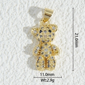 Macro view of a 18K gold teddy bear pendant with clear zircons and blue eyes detail