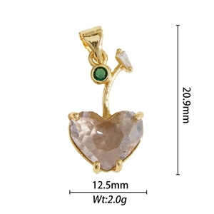 Détail macro du pendentif cerise cœur en cuivre doré avec incrustation de zircone