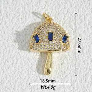 Macro detail of mushroom pendant with gold plating, white zircons, and blue stones