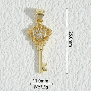 Macro detail of a gold-plated key pendant with zircon heart and dimensions 25x11mm
