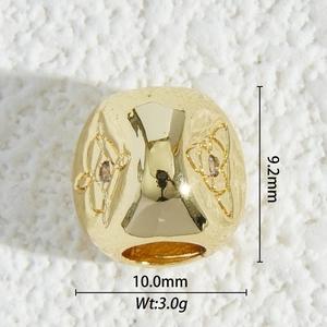 Macro shot of gold-plated heart bead with hollow pattern and dimensions for jewelry making