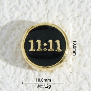 Macro detail of 10mm 18K gold plated 11:11 angel number charm with black enamel inlay