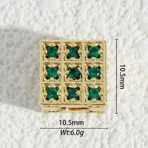 Macro view of a 10.5mm 18K gold-plated square charm with nine emerald green zircons