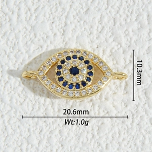 Macro shot of 18K gold plated evil eye connector with blue and white cubic zirconia