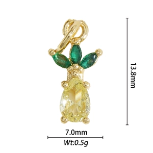 Detail van 18K goudvergulde ananas hanger met gele edelsteen en groene markies bladeren