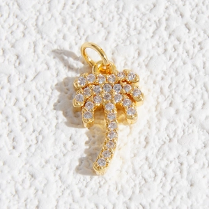 Dettaglio macro del ciondolo a palma con zirconi brillanti e placcatura in oro fine