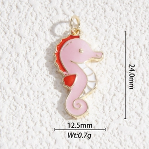 Macro view of gold-plated seahorse pendant with pink and orange enamel and size measurements