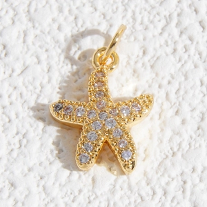 Dettaglio macro del ciondolo a stella marina dorata con micro-pavé di zirconi