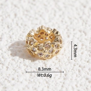 Macro view of gold flower charm with hollow petals, zircon inlay and product dimensions