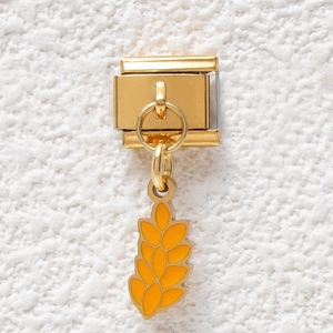 Detailed close-up of golden Italian charm bracelet link with yellow enamel wheat ear pendant