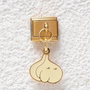 Close-up of a gold-plated Italian charm bracelet link featuring a cute garlic pendant