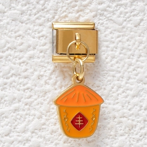 Detail of Italian modular charm with orange enamel bag and Chinese harvest symbol
