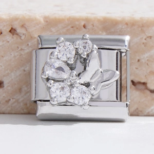 Détail macro du maillon de breloque modulaire avec grappe de cristal et papillon argenté