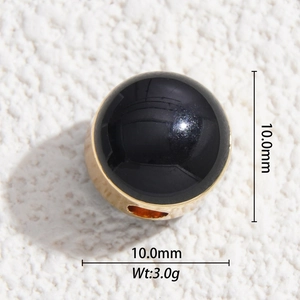 Macro detail of 10mm black enamel bead with gold plated base for jewelry making