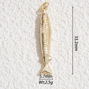 Macro detail of a 33mm gold-plated fish pendant with fine scales and fin textures