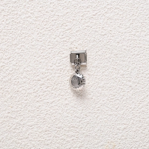 Macro detail of Italian charm bracelet link with engraved Queen crown on silver pendant