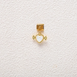 Detailed view of a gold Italian charm featuring a white iridescent winged heart pendant