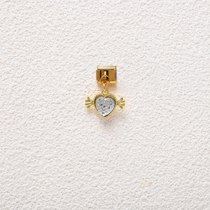 Detailed view of a gold heart charm with silver wings for modular charm bracelets